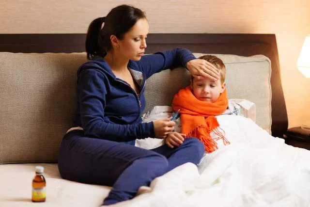 Mom taking temperature sick kid